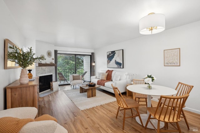 living area featuring a tiled fireplace and wood finished floors