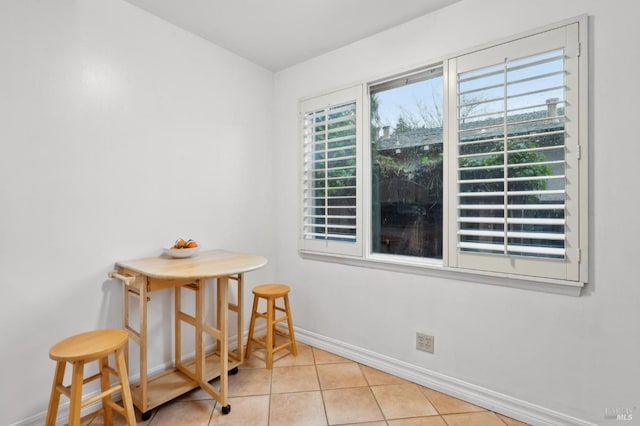 dining room with light tile patterned flooring and baseboards