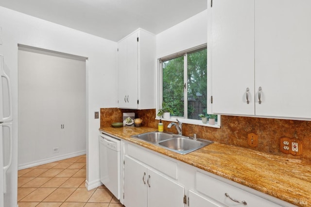 kitchen with tasteful backsplash, white cabinetry, a sink, light tile patterned flooring, and white appliances