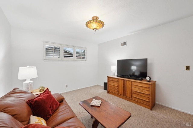 living area with baseboards, visible vents, and light colored carpet