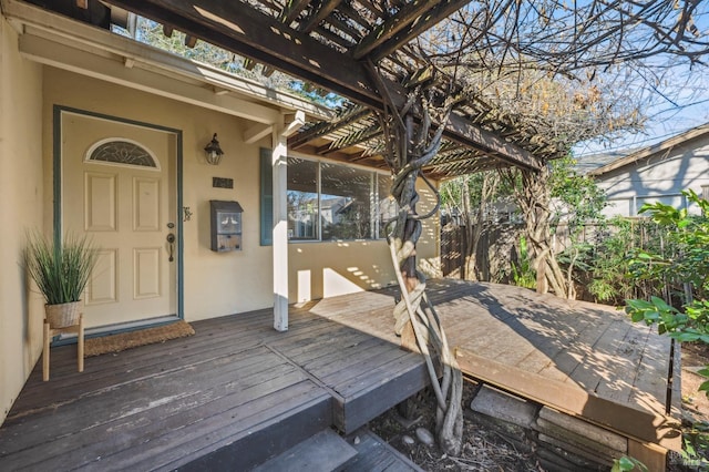 deck featuring fence and a pergola