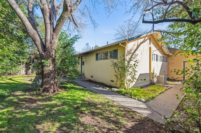 view of home's exterior with a yard, crawl space, cooling unit, and stucco siding