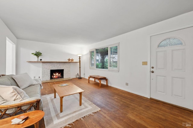 living room with a fireplace, baseboards, and wood finished floors