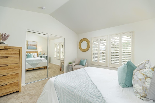 bedroom with a closet, lofted ceiling, and light colored carpet