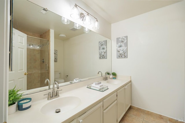 bathroom with vanity, toilet, a shower with shower door, and tile patterned floors