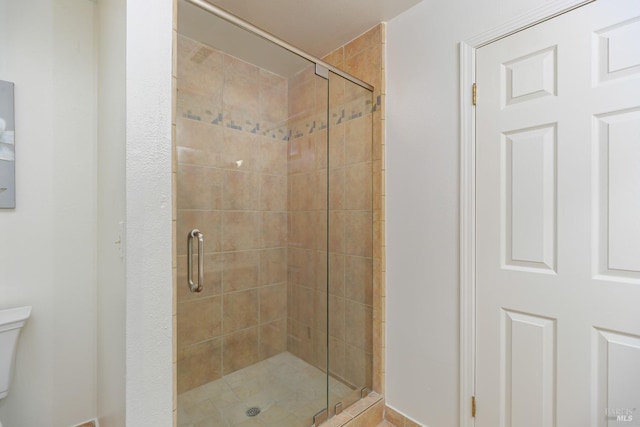 bathroom featuring an enclosed shower and toilet