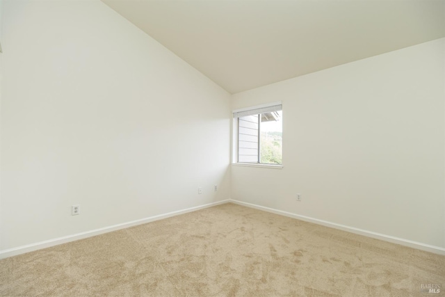 carpeted spare room featuring lofted ceiling