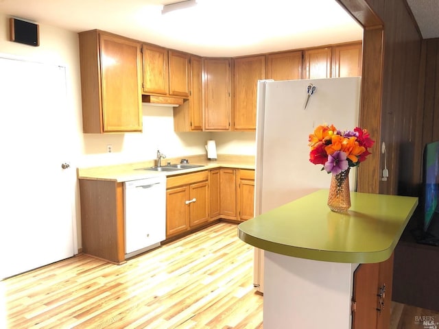 kitchen with white appliances, light wood-type flooring, and sink