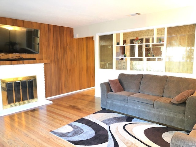 living room with hardwood / wood-style floors and wood walls