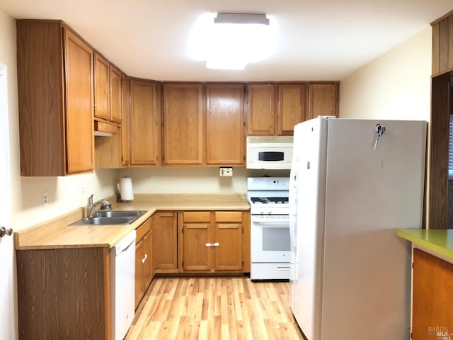 kitchen with white appliances, light hardwood / wood-style floors, and sink