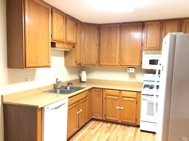 kitchen with sink, white appliances, and light wood-type flooring