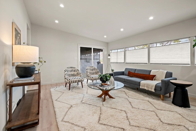 living area with recessed lighting, lofted ceiling, baseboards, and wood finished floors