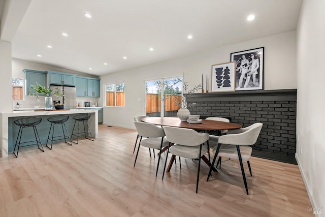 dining room with recessed lighting, vaulted ceiling, light wood-style flooring, and baseboards