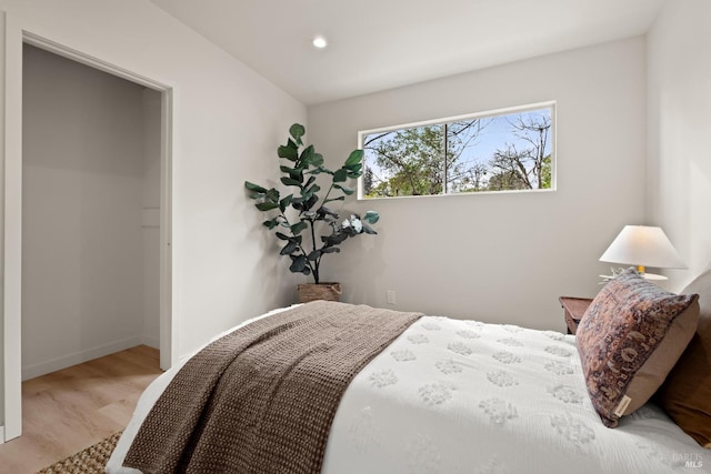 bedroom with baseboards, wood finished floors, and recessed lighting