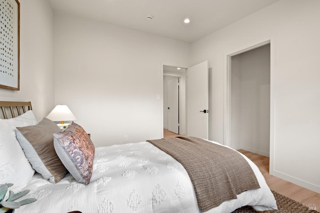 bedroom featuring baseboards, light wood-style flooring, and recessed lighting