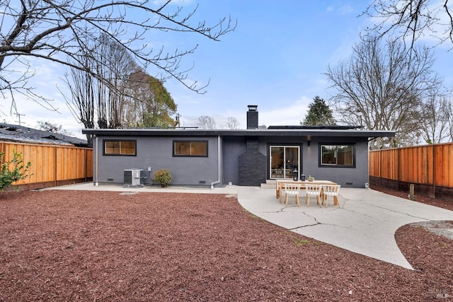 back of property featuring a chimney, crawl space, a patio area, cooling unit, and a fenced backyard