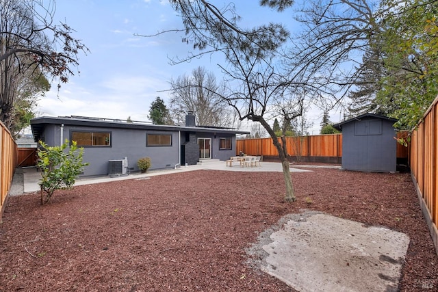 rear view of house with a storage shed, central AC unit, a patio area, and a fenced backyard