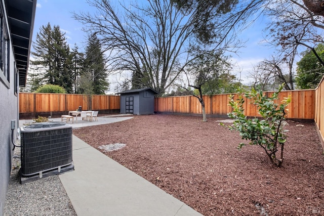 view of yard with central AC unit, a fenced backyard, a storage shed, an outdoor structure, and a patio area