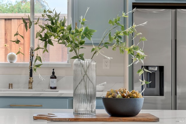 details featuring light countertops, a sink, and stainless steel refrigerator with ice dispenser