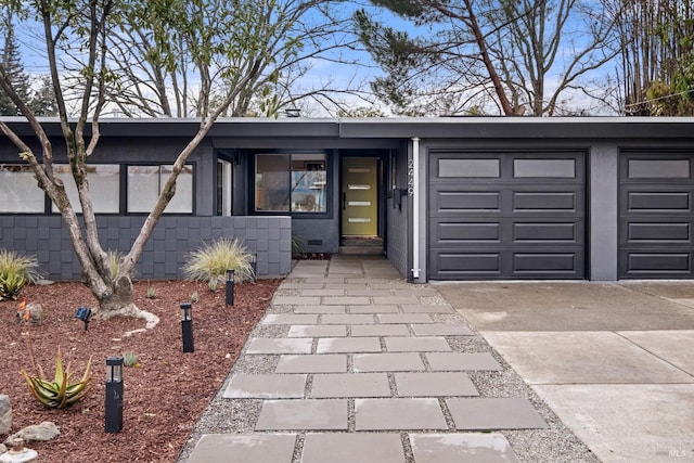 mid-century modern home featuring a garage and driveway