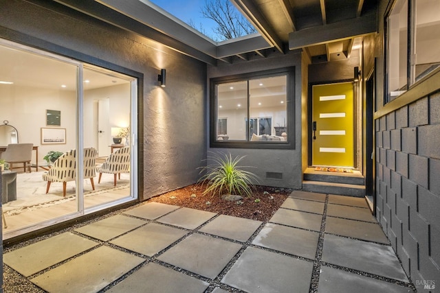 property entrance featuring crawl space, a patio, and stucco siding