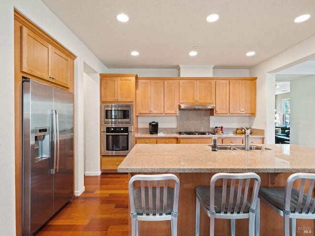 kitchen with dark wood-style flooring, stainless steel appliances, recessed lighting, under cabinet range hood, and a sink