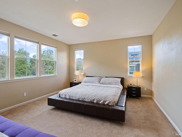 carpeted bedroom with visible vents and baseboards