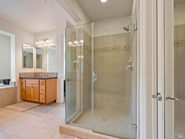 bathroom with tile patterned flooring, vanity, and a shower stall