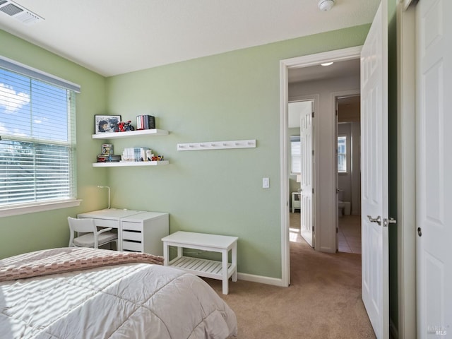 bedroom with baseboards, visible vents, and light colored carpet