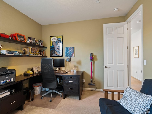 office space with baseboards and light colored carpet