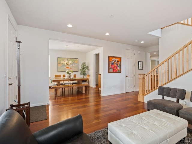 living room featuring stairway, recessed lighting, baseboards, a notable chandelier, and wood finished floors