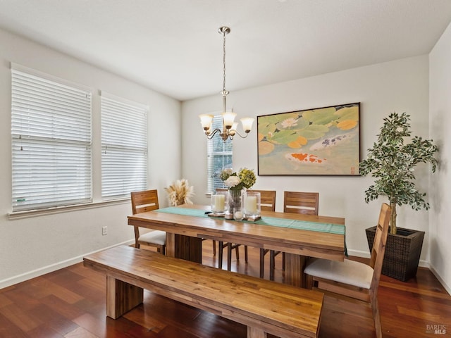 dining space with baseboards, a notable chandelier, and wood finished floors
