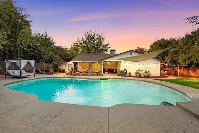 pool at dusk featuring a fenced in pool, outdoor lounge area, central AC, a patio area, and a fenced backyard