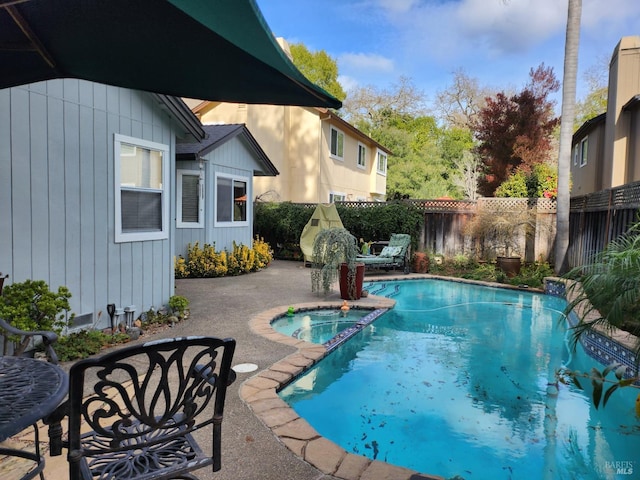 view of swimming pool featuring a patio and an in ground hot tub