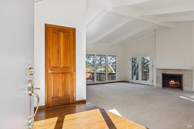 living area with a tiled fireplace, light carpet, high vaulted ceiling, beamed ceiling, and baseboards