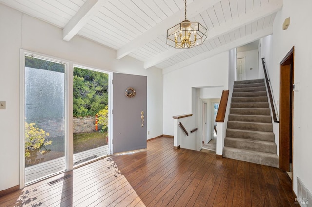 foyer entrance with visible vents, lofted ceiling with beams, dark wood-type flooring, stairs, and a notable chandelier