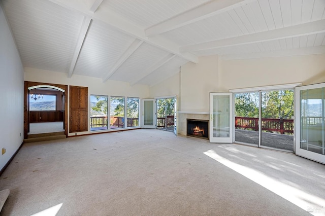 unfurnished living room with carpet floors, a fireplace with flush hearth, high vaulted ceiling, and beam ceiling