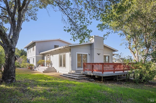 rear view of property featuring a lawn and a wooden deck