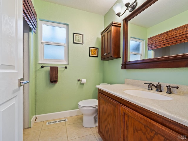 bathroom featuring visible vents, toilet, vanity, tile patterned flooring, and baseboards