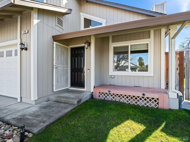 property entrance with a yard and an attached garage