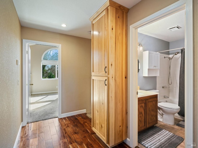 full bath featuring toilet, vanity, visible vents, baseboards, and shower / bath combination with curtain