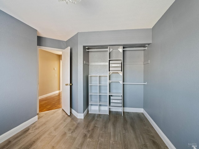 unfurnished bedroom with baseboards and wood finished floors