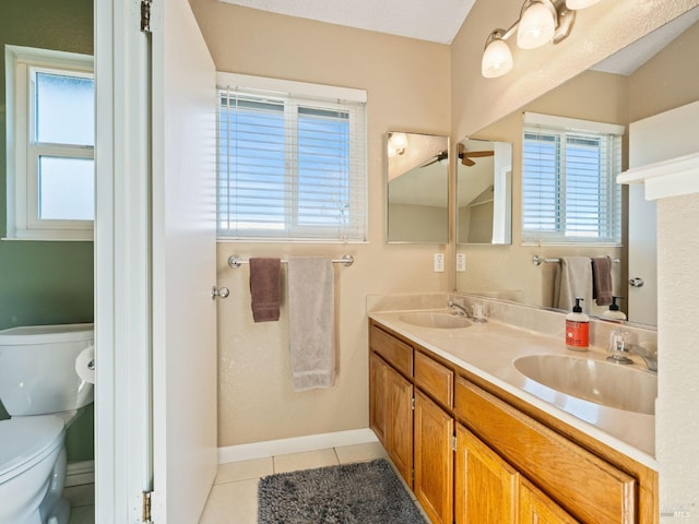 bathroom with toilet, tile patterned flooring, double vanity, and a sink