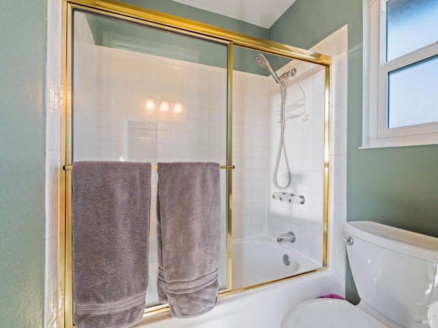 bathroom with toilet and combined bath / shower with glass door