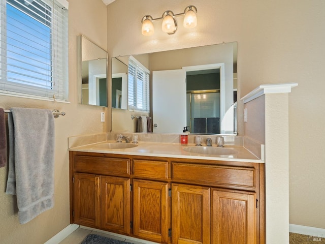 full bath featuring double vanity, baseboards, and a sink