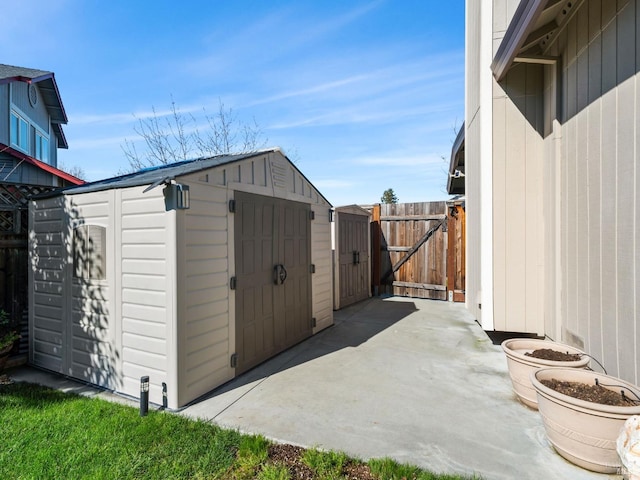 view of shed with fence and a gate