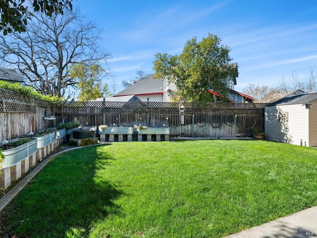 view of yard with an outbuilding, a fenced backyard, a vegetable garden, and a storage shed