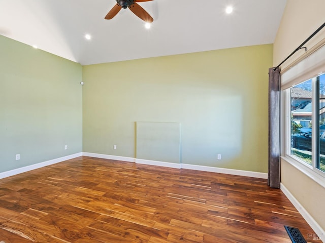 spare room featuring lofted ceiling, dark wood-style flooring, visible vents, and baseboards