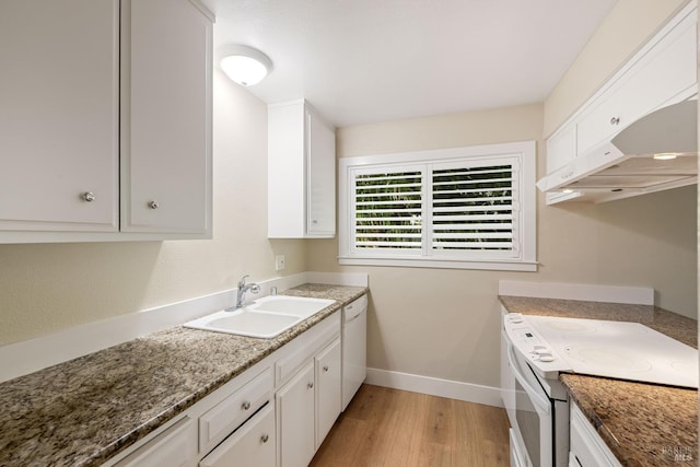 kitchen with white appliances, dark stone countertops, light hardwood / wood-style flooring, sink, and white cabinets