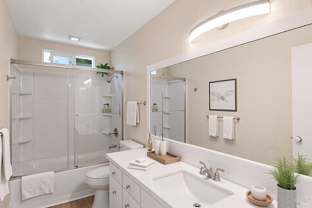 full bathroom with toilet, vanity, and shower / bath combination with glass door